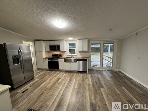 A kitchen with a refrigerator, microwave, oven, and sink is available for rent.