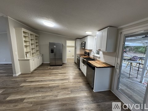 A kitchen with wooden floors and white cabinets is available for rent.