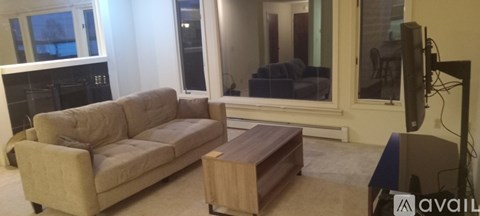 A living room with a couch, a coffee table, and a television.