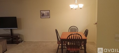 A dining room with a wooden table and chairs.