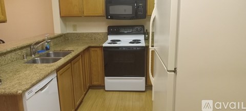 A kitchen with a sink, stove, and refrigerator.
