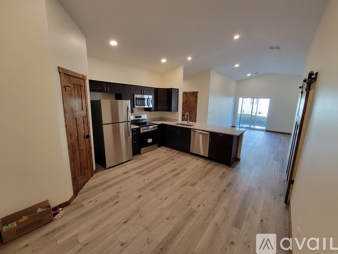 A spacious kitchen with wooden flooring and modern appliances.