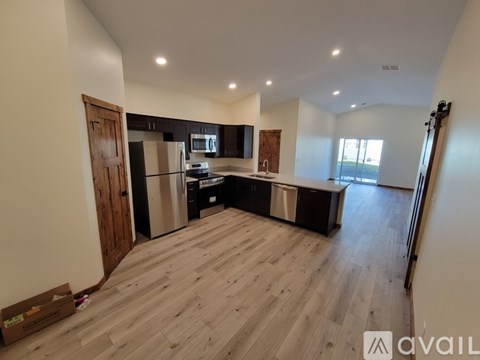 A spacious kitchen with wooden flooring and modern appliances.