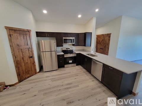 A kitchen with wooden floors and a refrigerator.