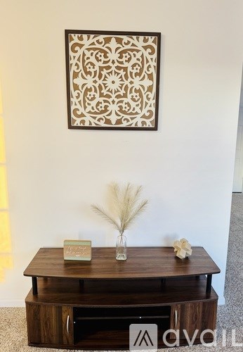 A wooden table with a vase and a book on it.