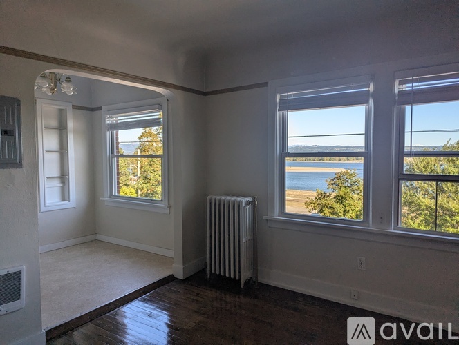 A room with a large window overlooking a parking lot and a body of water.