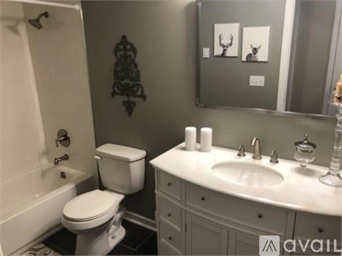 A white toilet sits next to a white sink in a bathroom.