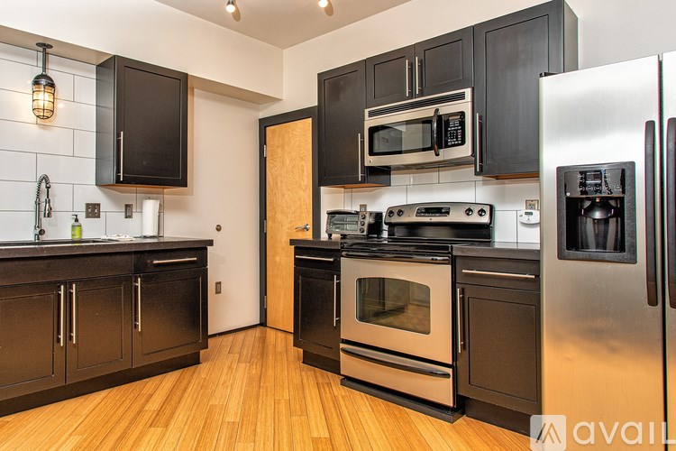 A kitchen with black cabinets and stainless steel appliances.