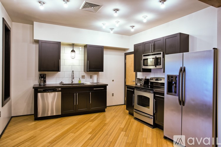 A kitchen with wooden floors and stainless steel appliances.