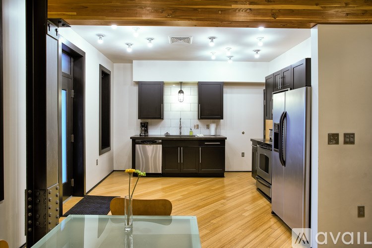 A modern kitchen with a glass table and stainless steel appliances.