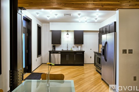 A modern kitchen with a glass table and stainless steel appliances.
