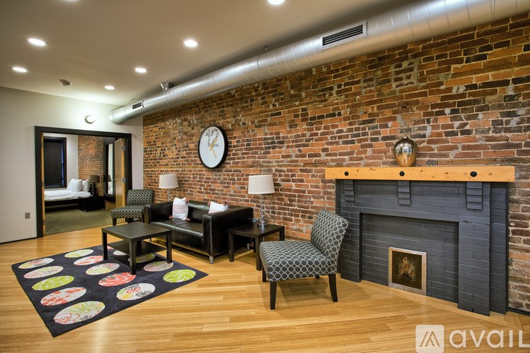 A living room with a brick wall and a fireplace.