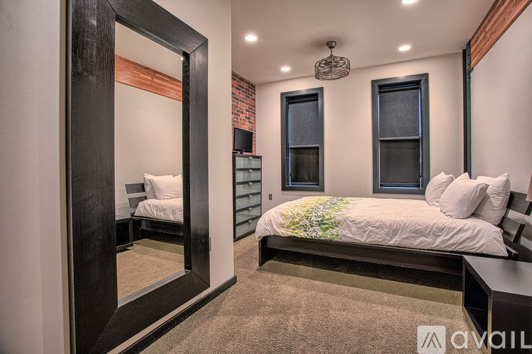A bedroom with a large bed and a mirror on the wall.