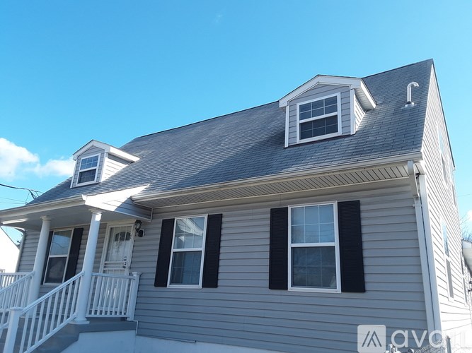 A white door with a window in the middle is in a room with a ceiling fan.