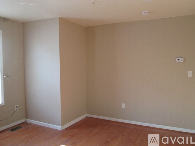 Empty room with wooden floors and white walls.