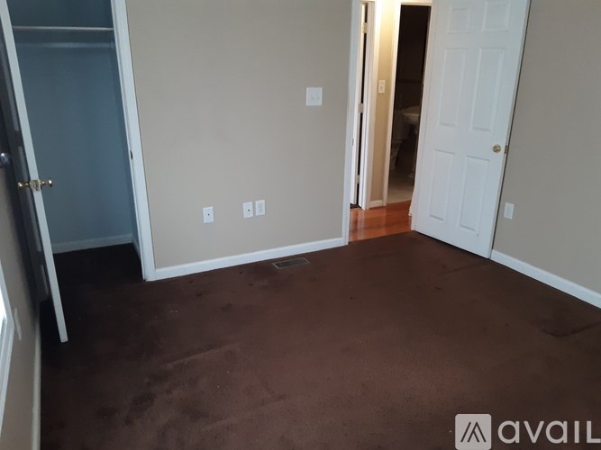 A room with brown carpet and white walls.