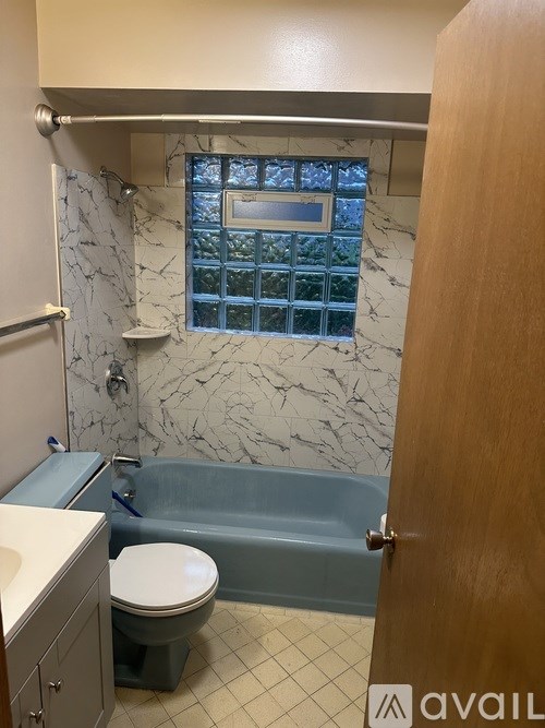 A bathroom with a toilet, sink, and tub.