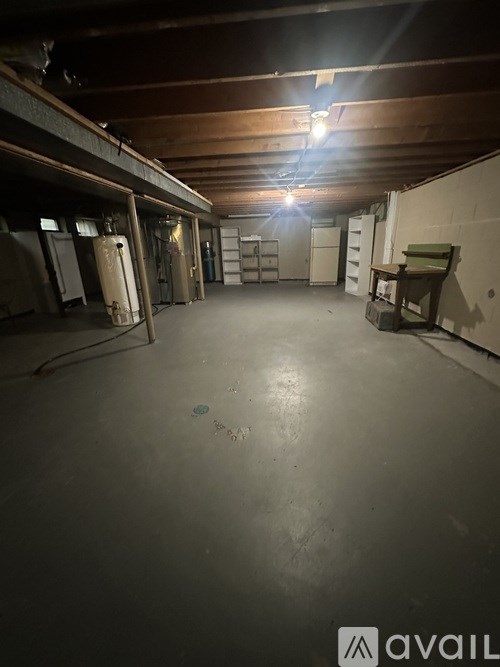 A large, empty warehouse with a concrete floor and wooden ceiling.