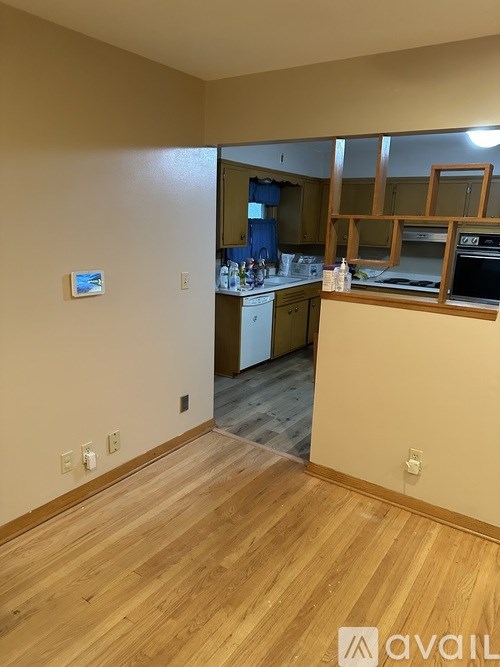 A kitchen with wooden floors and a countertop with a sink.
