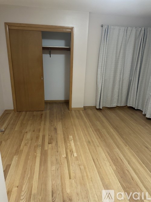 A room with a wooden floor and a wooden door with a shelf above it.