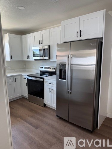 A kitchen with a refrigerator, stove, and microwave.