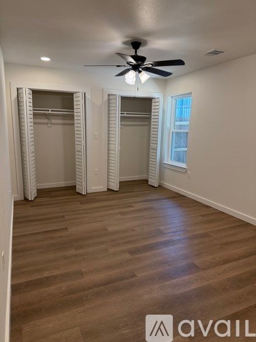 A room with a ceiling fan and wooden flooring.