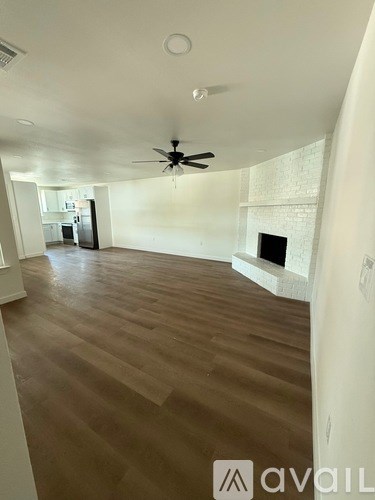 A room with wooden flooring and a ceiling fan.