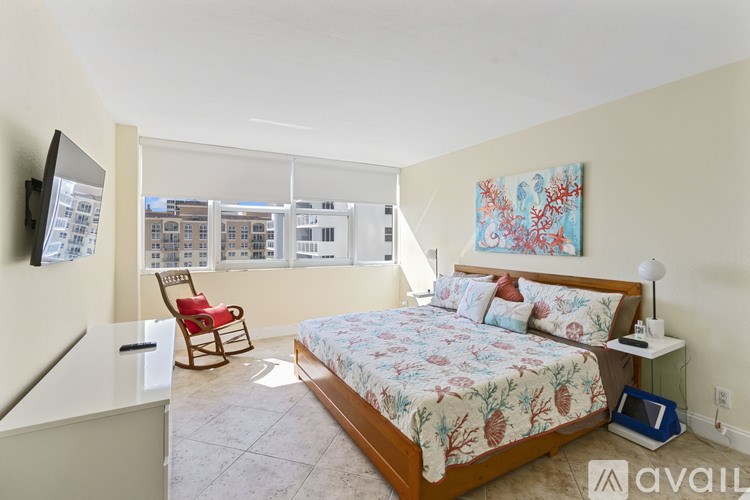 A bedroom with a large bed and a chair.