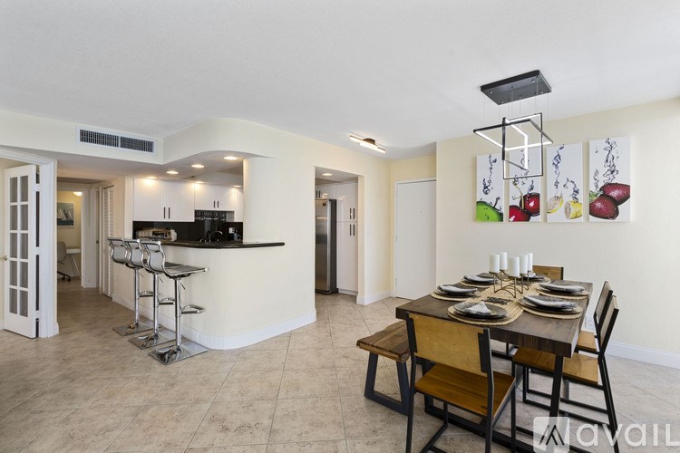 A modern kitchen with a dining table set for four.