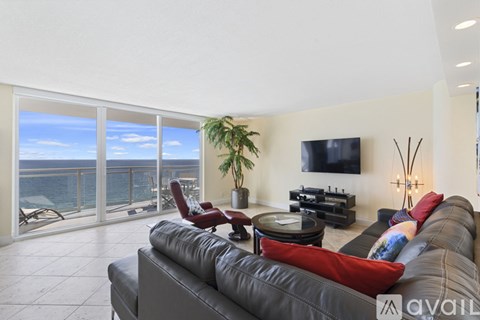 A living room with a grey couch and a flat screen TV mounted on the wall.
