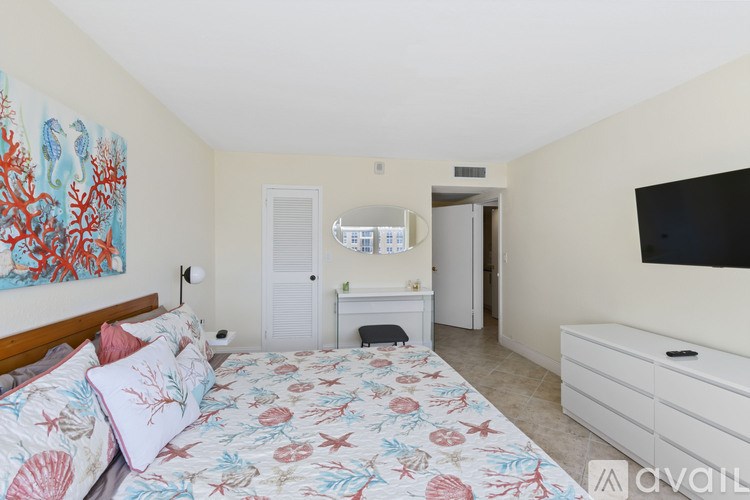 A bedroom with a large bed and a painting on the wall.