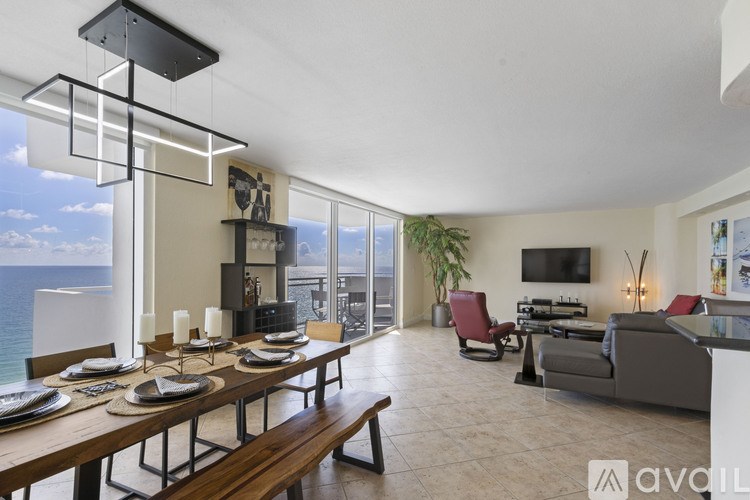 A modern dining room with a long table set for a meal.