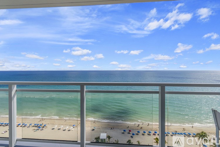 A beach scene with people and umbrellas on the sand.