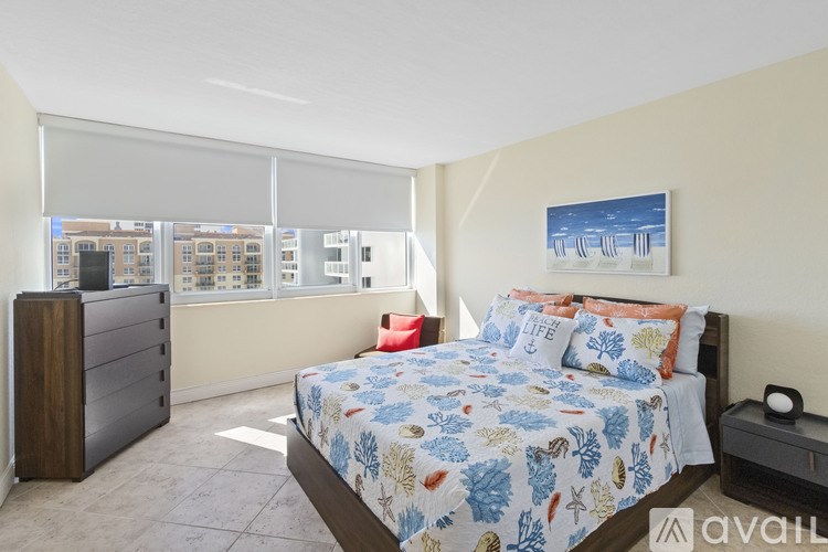 A bedroom with a large bed and a wooden dresser.