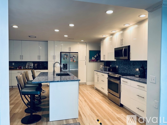 A modern kitchen with white cabinets and a central island.