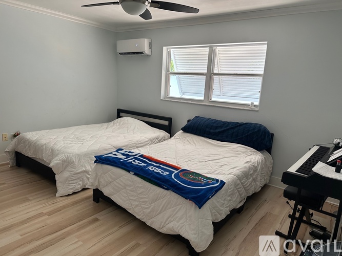 A bedroom with two beds and a piano.