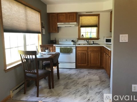 A kitchen with a table and chairs in front of a window.