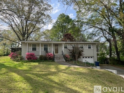 A house with a front yard and trees in the background.
