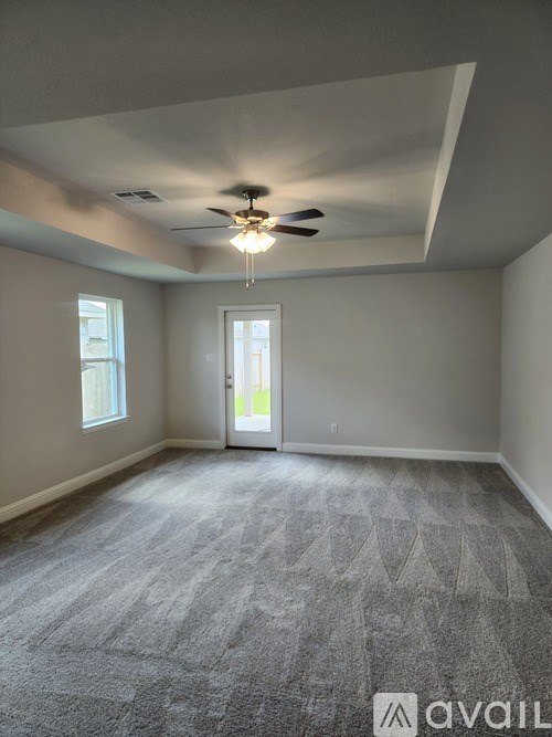A room with a ceiling fan and carpeted floor.