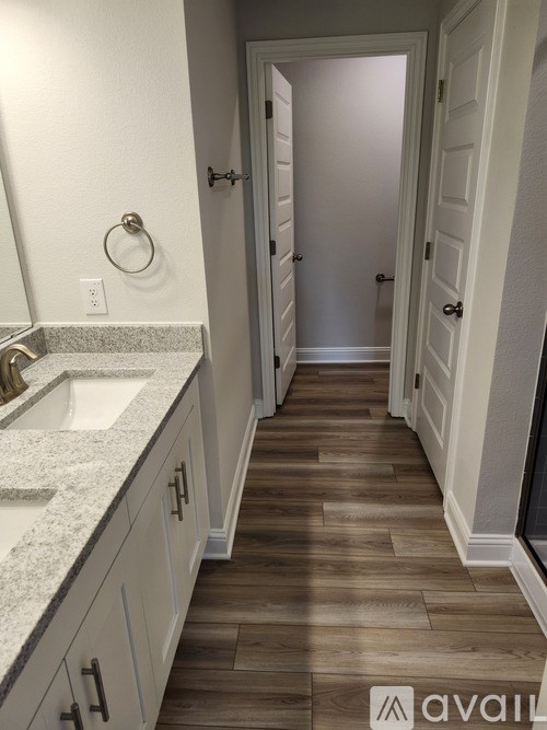 A bathroom with a sink and a wooden floor.