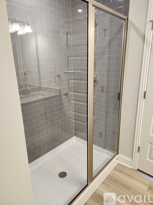 A bathroom with a glass shower door and a white sink.