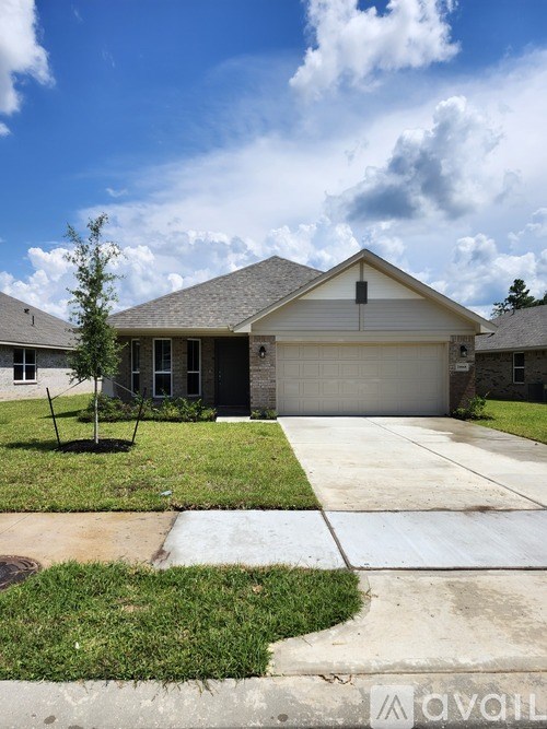 A house with a garage and a tree in front.
