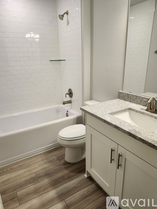 A white toilet sits in a bathroom next to a bathtub and a sink.
