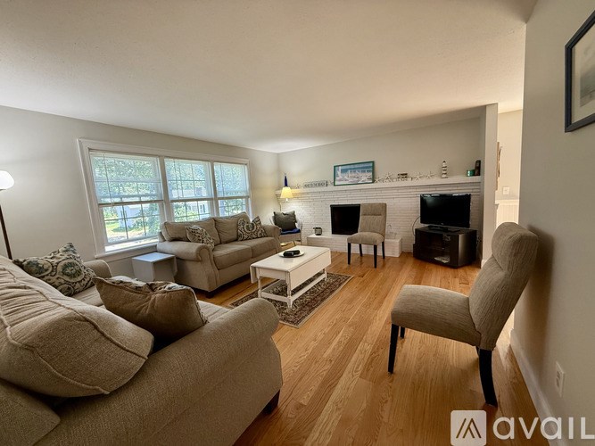 A living room with a couch, chair, and television.