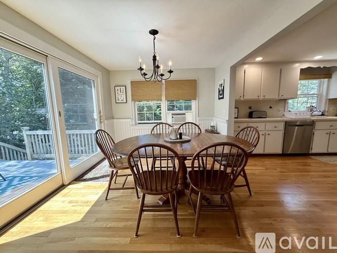 A dining room with a wooden table and chairs.
