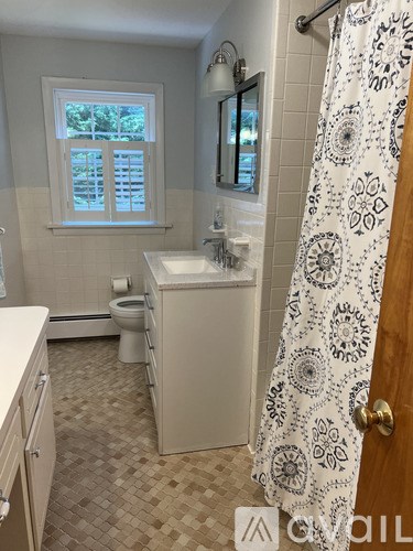 A bathroom with a toilet, sink, and shower.