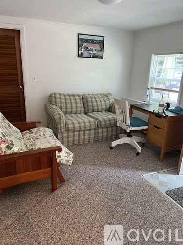 A room with a couch, chair, and desk.