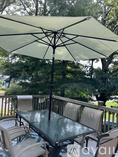 A table with chairs and an umbrella on a patio.