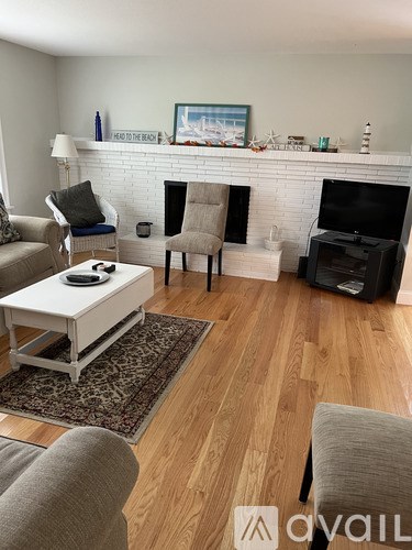 A living room with a fireplace and a TV.