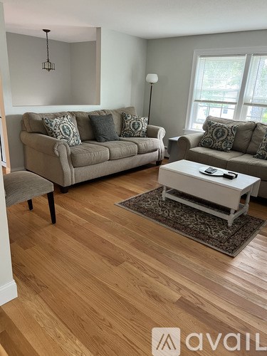 A living room with a couch, chair, and coffee table.